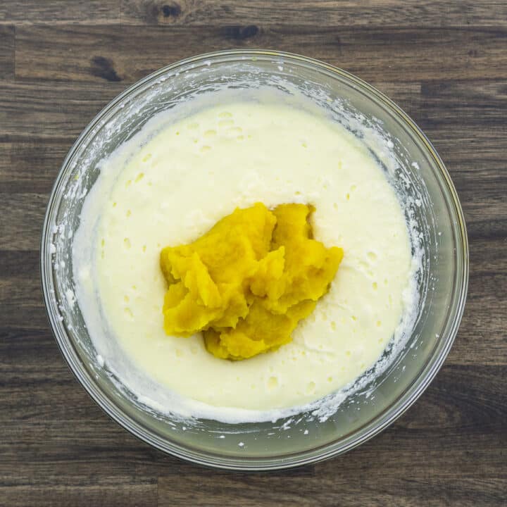A bowl with butter egg mixture and pumpkin puree.