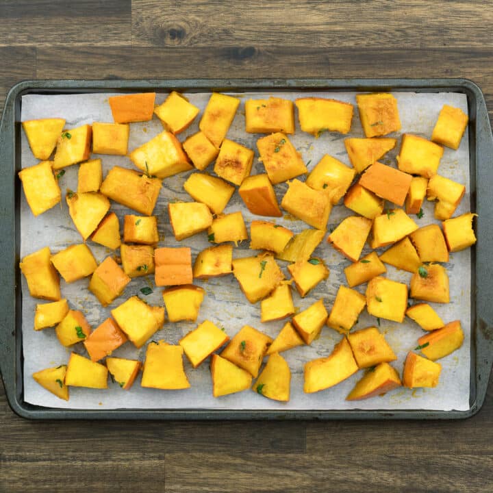 Seasoned Pumpkin on a baking tray lined with parchment paper.