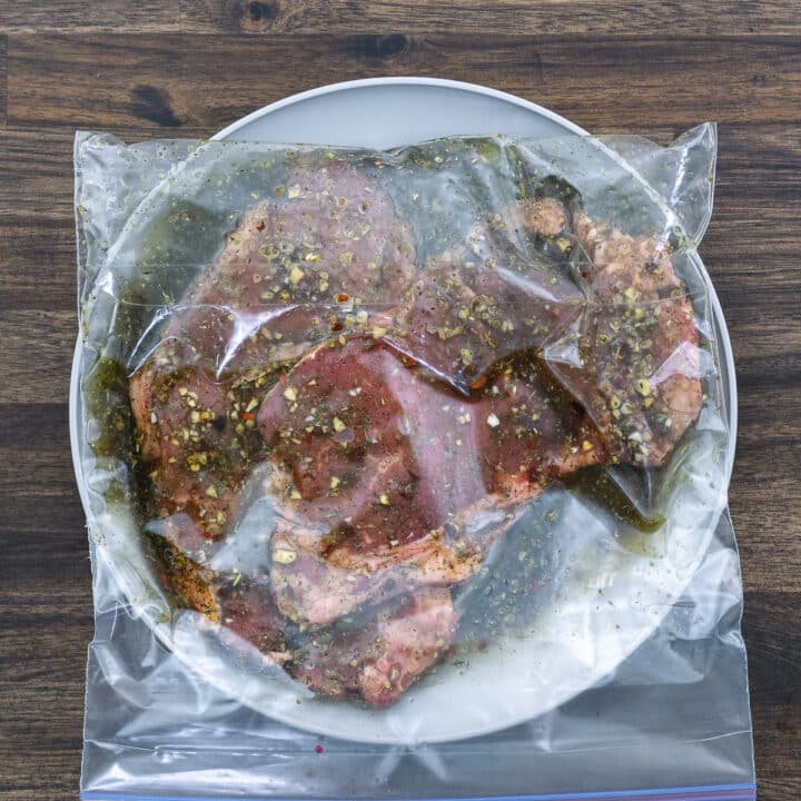 A ziplock bag with Steak marinated in a marinade.