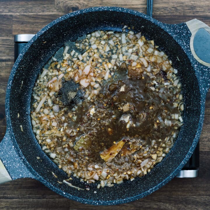 A pan with chicken adobo sauce that includes brown sugar and basic seasonings.
