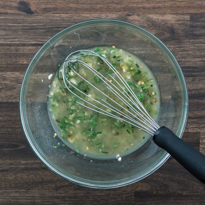 A bowl with Greek Chicken Marinade with whisk.
