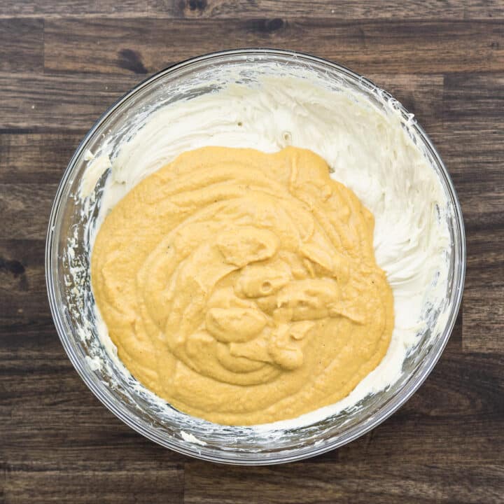 A bowl with cream cheese and pumpkin mix.
