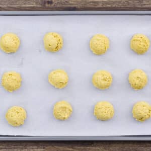 Pumpkin cookie dough neatly placed on a baking tray lined with parchment paper.