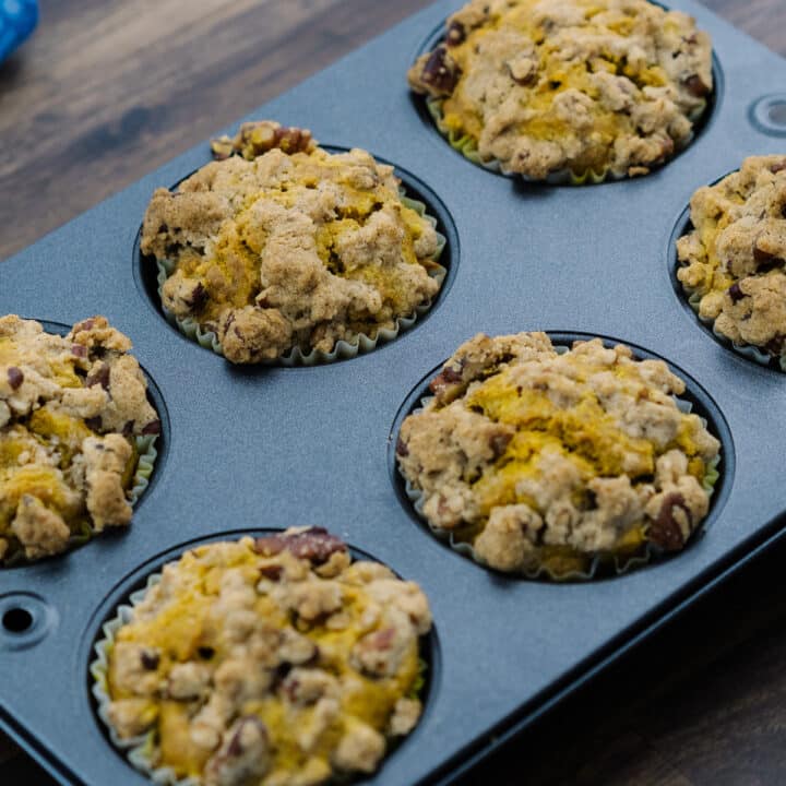 Streusel topped Pumpkin Muffins in a muffin tray.