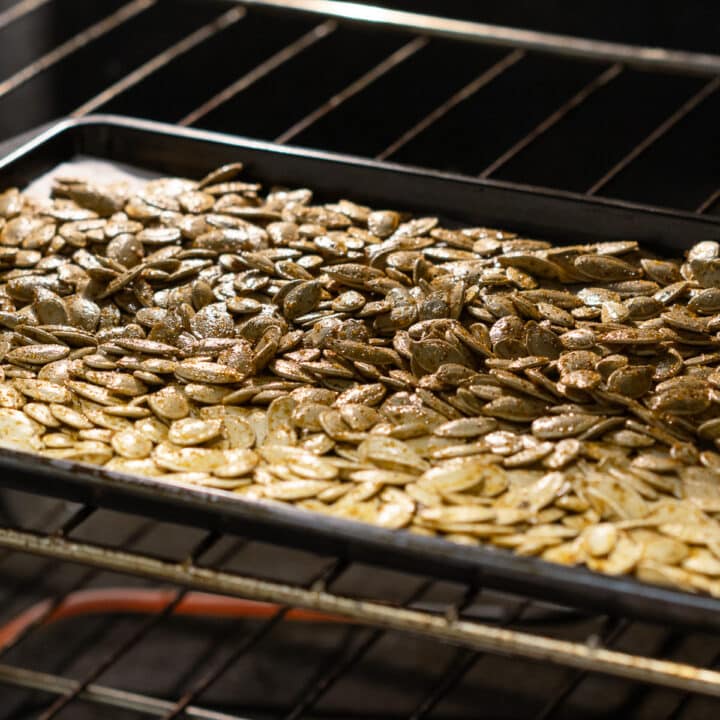 Seasoned Pumpkin seeds on a baking tray inside the oven.