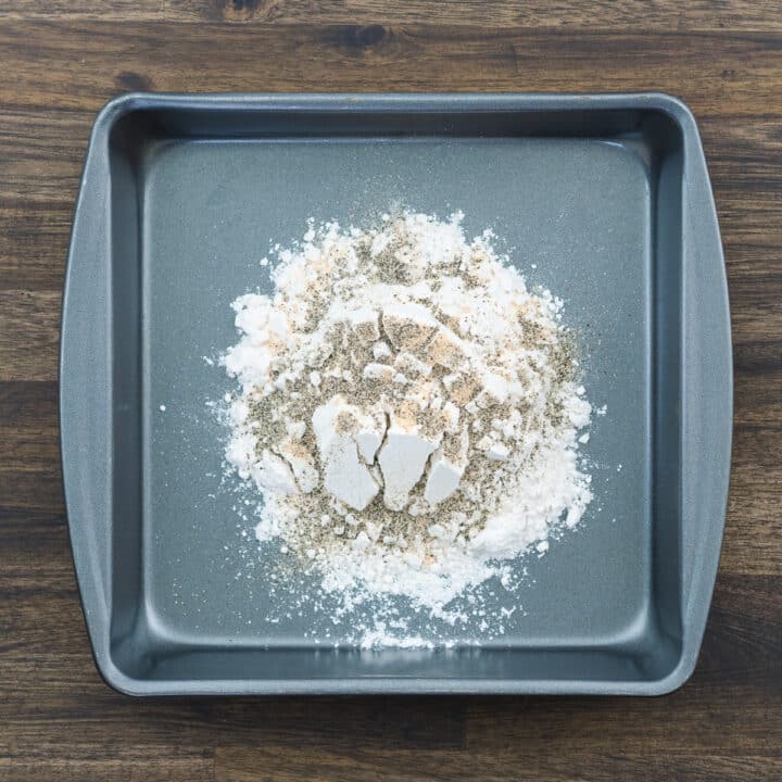 Tray of flour sprinkled with seasoning powders.