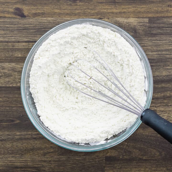 A bowl with a mixture of all-purpose flour, cornstarch, baking soda, and salt, whisked using a whisker.