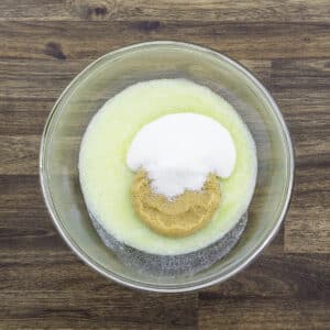 A bowl with melted butter, brown sugar, and white sugar.