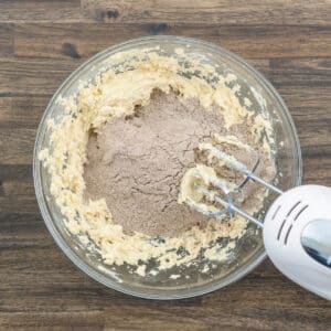 A bowl combining the butter mix with the flour mix using the electric beater.