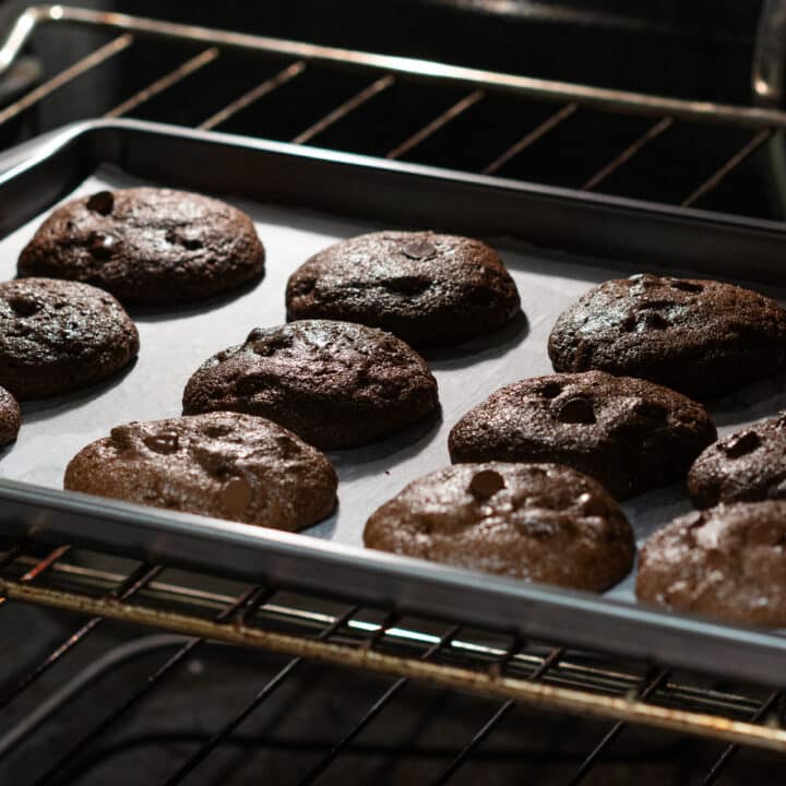 A baking tray with the cookie dough baking in the oven.
