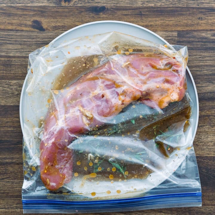 A ziplock bag with pork loin and marinade inside.