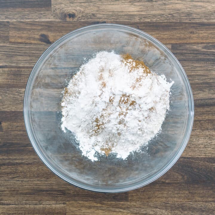 A bowl containing flour, salt, baking agents, and pumpkin pie spice.