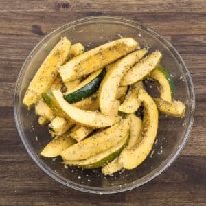 A bowl filled with expertly seasoned acorn squash, ready for the next step.