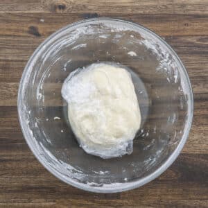 Shortbread cookie dough wrapped in plastic in a bowl.