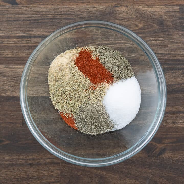 A bowl containing ingredients for homemade steak seasoning.