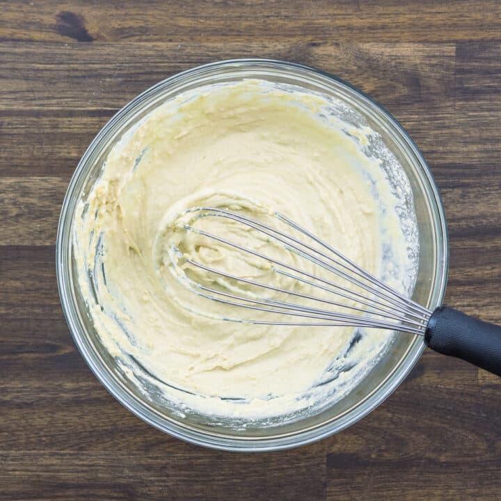 Bowl containing tahini sauce with whisk.