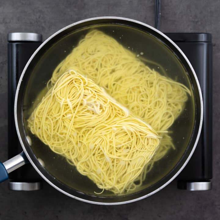 A pan filled with hot water and Chow Mein noodles.