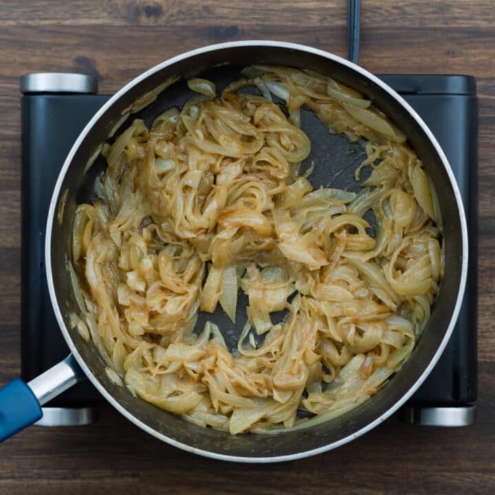 Caramelized onions sizzling in a pan.