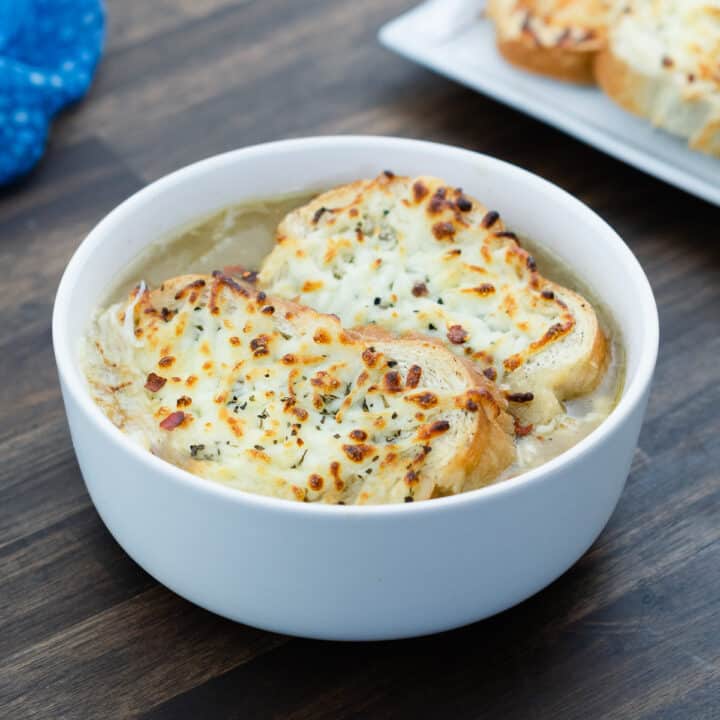 A bowl showcasing French Onion soup, topped with cheesy toasted bread.