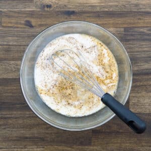 Whisked egg-milk custard mixture in a bowl.