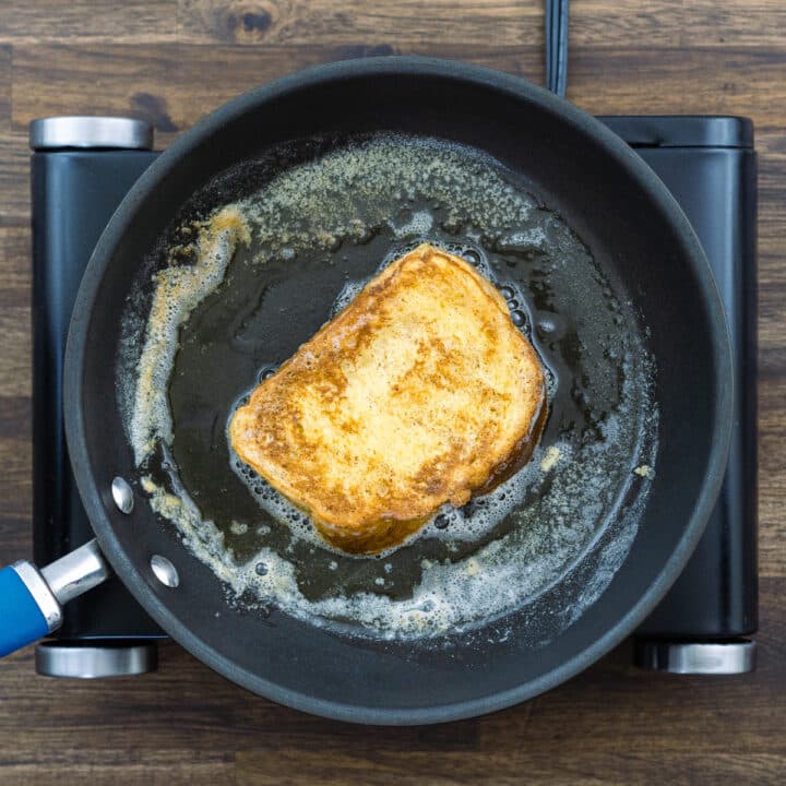 Golden French Toast sizzling in a pan.