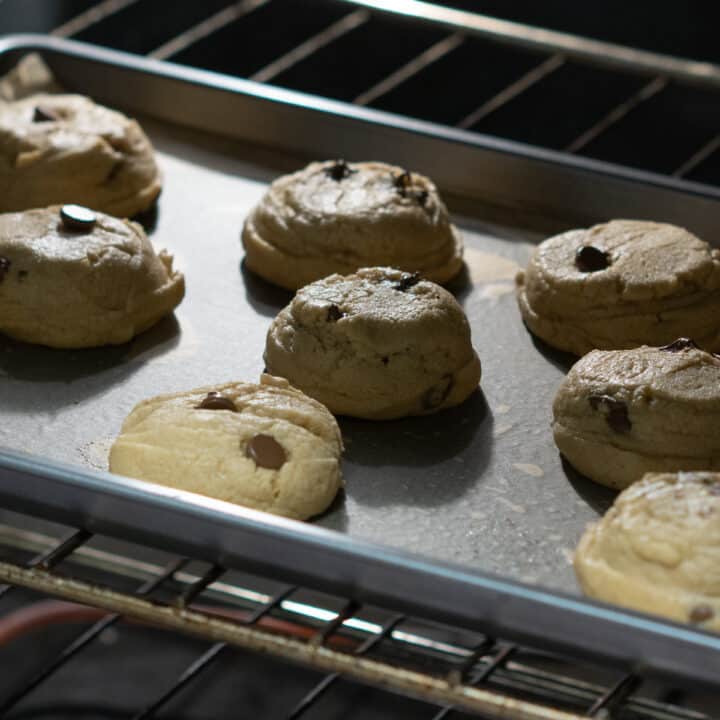 Peanut butter chocolate chip cookie dough baking inside the oven.