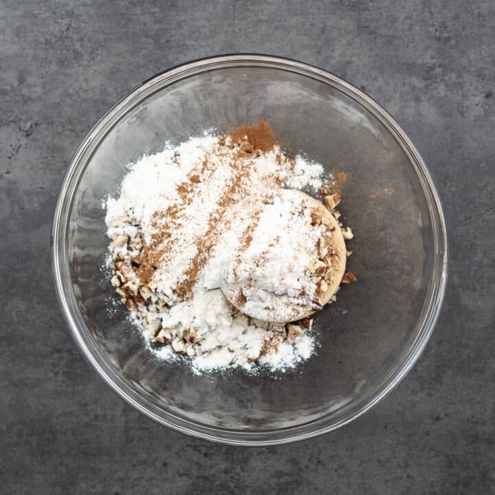 Bowl filled with streusel topping ingredients, including pecans, brown sugar, and flour.