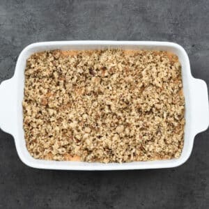 Assembled Sweet Potato Casserole mix topped with streusel in a casserole dish.