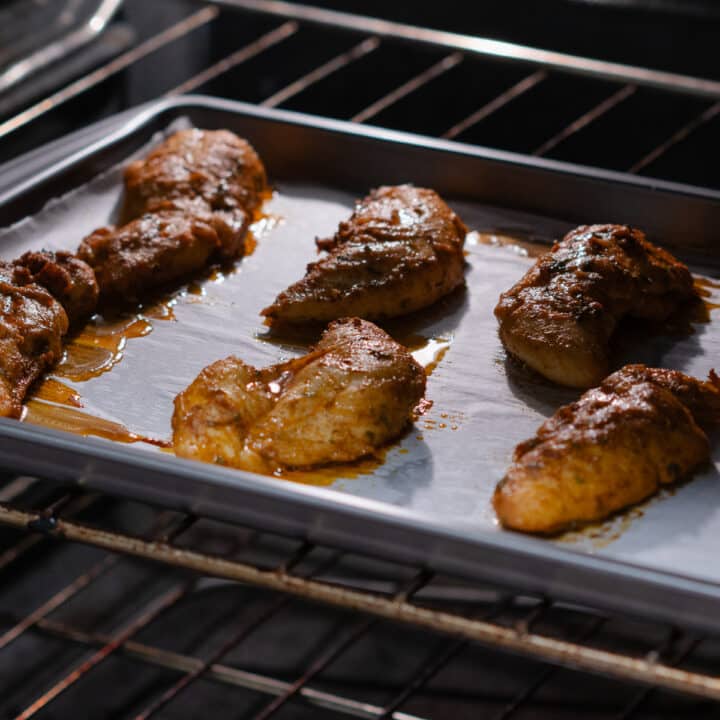 Chicken tenders in the oven, undergoing a flavorful transformation as they bake to perfection.