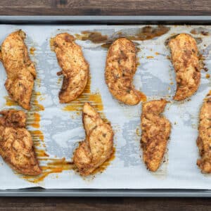 Golden Baked Chicken Tenders served in a parchment-lined baking tray.