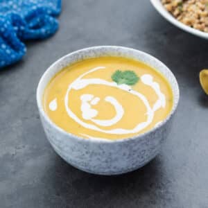 Creamy butternut squash served in a bowl with farro alongside as a side.
