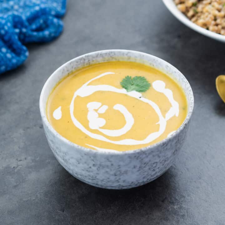 Creamy butternut squash served in a bowl with farro alongside as a side.