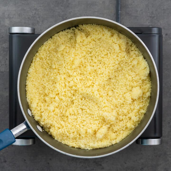 Nicely cooked and fluffed couscous in a wide-bottomed pan.