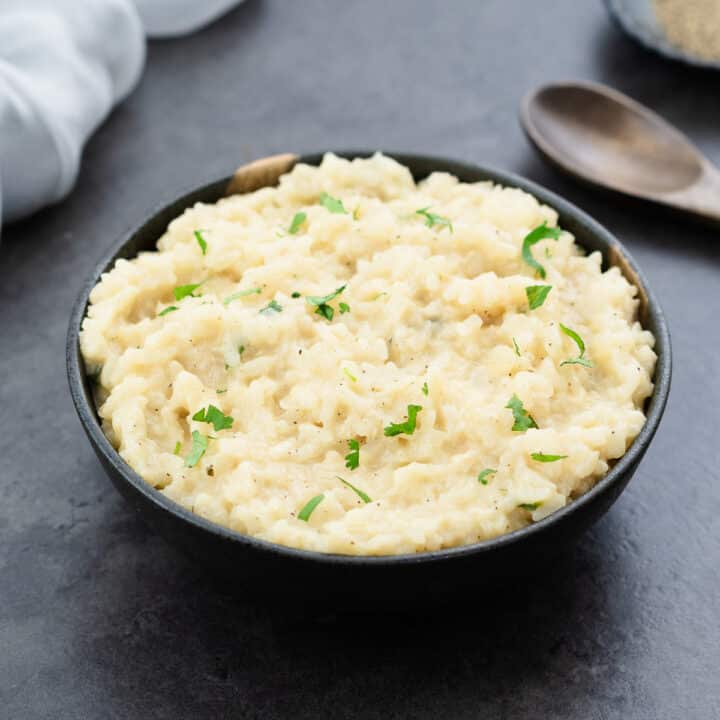 Risotto served in a grey bowl with parsley.