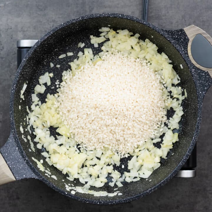 A pan with Arborio rice with sauteed aromatics.