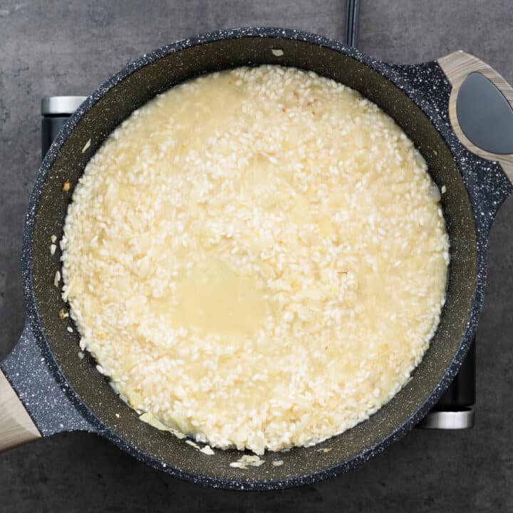 Rice with chicken broth in a pan.