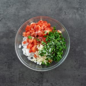 A bowl with Pico De Gallo ingredients.
