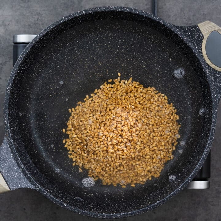 A wide-bottomed pan filled with water and farro.