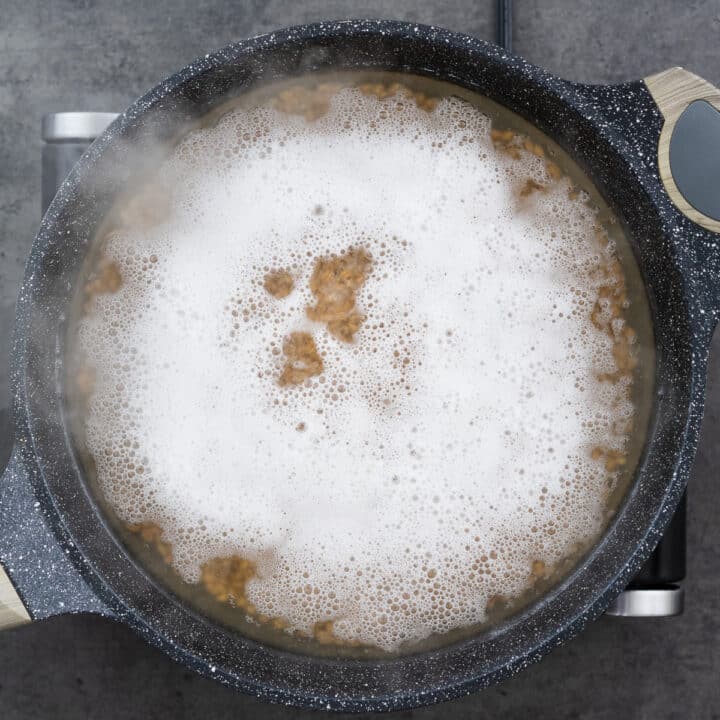 Farro boiling in water in a wide pan.