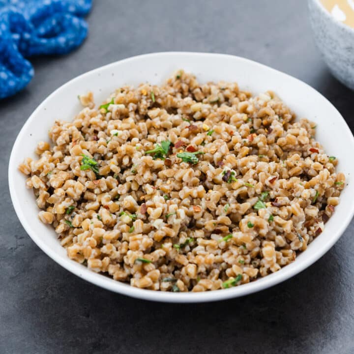 Cooked farro served in a white bowl.