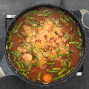 Ingredients for Minestrone Soup simmering in broth.