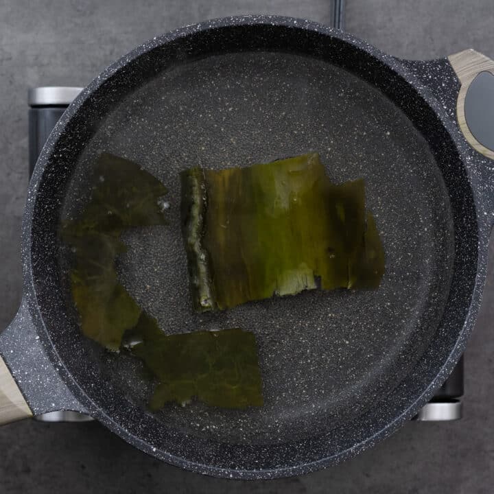 Kombu and water simmering in a pot over medium-low heat.