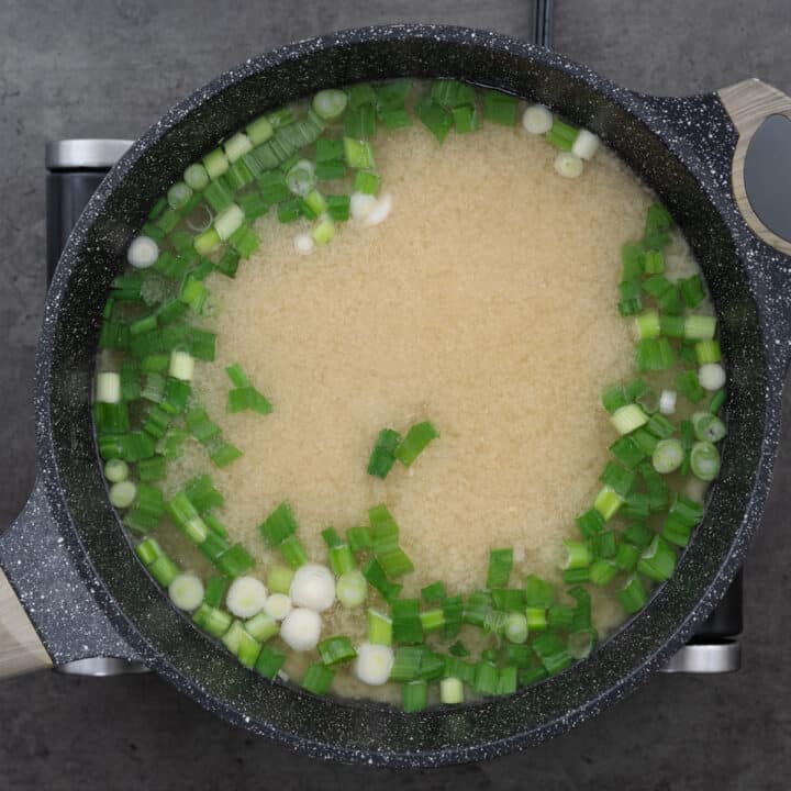 Miso Soup simmering with green onions in a pot.