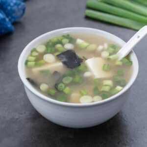 Miso Soup served in a white bowl with a white spoon.