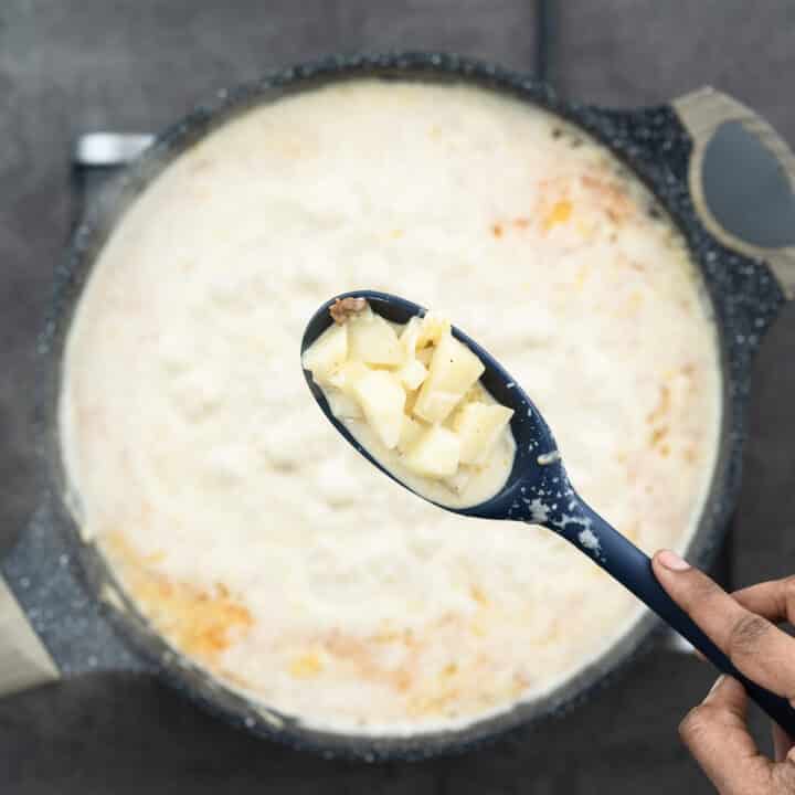 Showing the texture of Cooked potato pieces on a blue spoon.