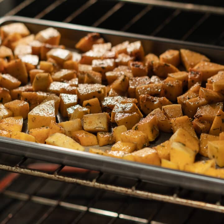 Seasoned butternut squash roasting inside the oven.
