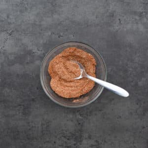 A bowl of salmon seasoning accompanied by a spoon.