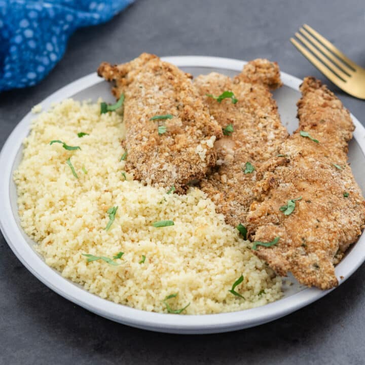 Air Fryer Chicken Tenders served with couscous on a white plate.