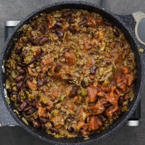 A pot with ground beef, kidney beans, and tomatoes.