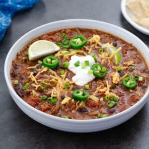 A bowl of beef chili served in a white bowl.